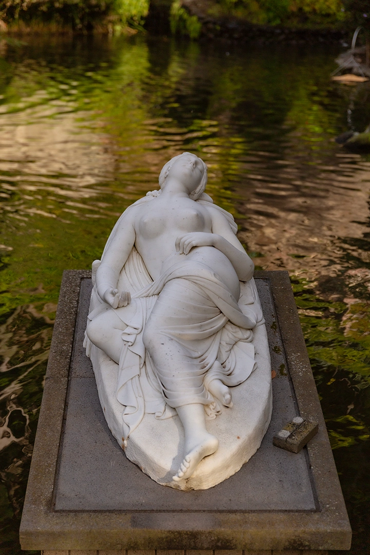 Kaunis veistos Monten puutarhan lammen rannalla.